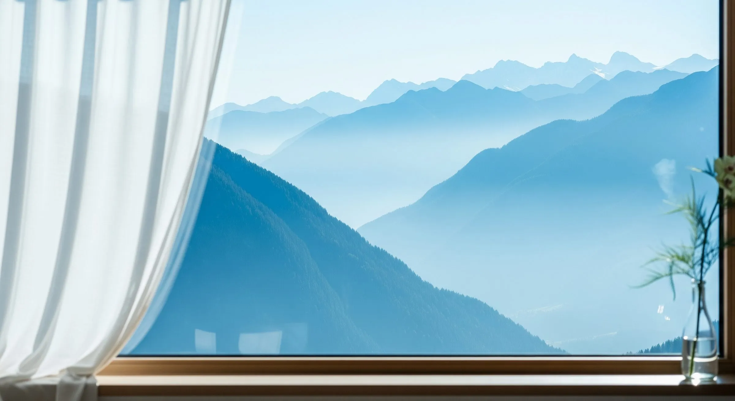 Alpenpanorama im Morgendunst durch ein offenes Fenster